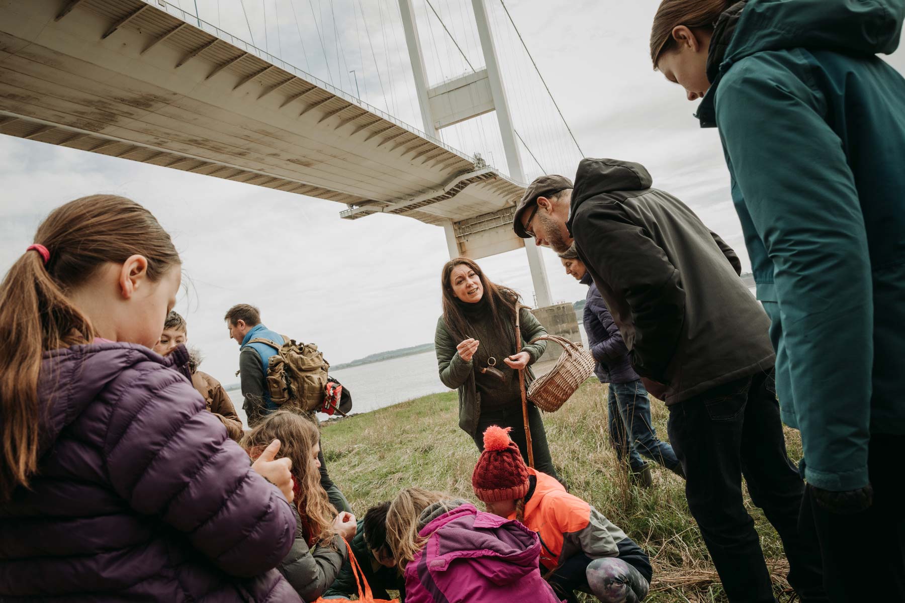 Local forager educates customers on the local habit against the backdrop of the Severn Estuary and bridge