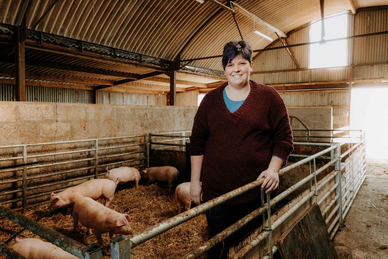 Monmouthshire Fayre owner and farmer, Jessi, stood in a barn surrounded by pigs.