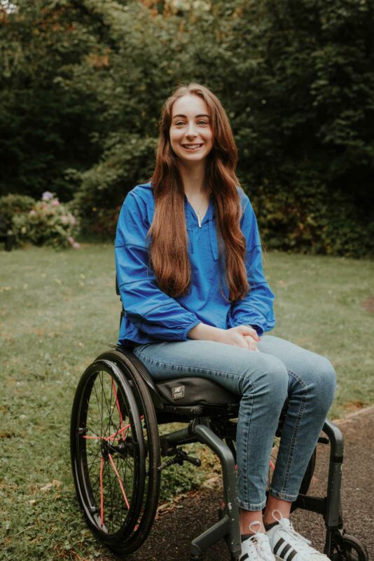 Portrait of young disability actvivist Bethany Handley sat in her wheelchair in a community garden in Monmouth, South Wales.