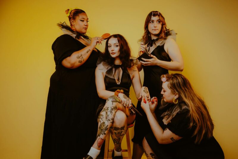 All-girl Newport pop punk band Murder Club posing against a yellow backdrop during a promotional press shoot. Shot at Digichemistry Studios.
