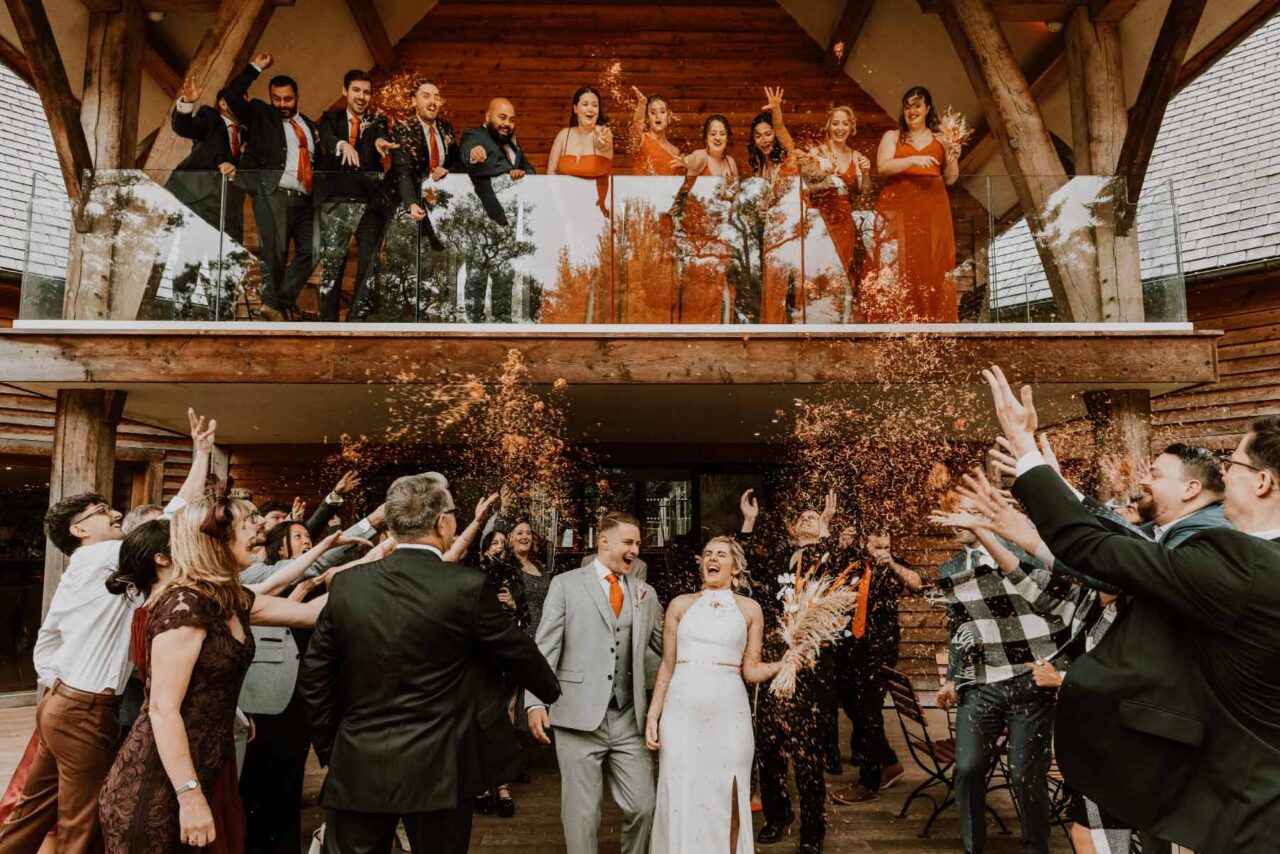 Happy couple being showered in autumnal confetti at the Millbarns, Shropshire.