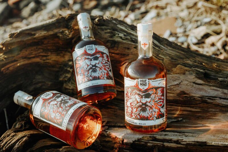 Promotional product image of a bottle of Hive Mind rum aged mead set in a coastal, shipwrecked styled setting. Shot as part of a promotional marketing shoot, Nov 2024.